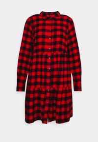 Vestito camicia a quadri rossi e neri con colletto, bottoni sul davanti, maniche lunghe e design della gonna a balze. Tessuto morbido al tatto.