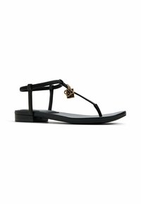 Black flat sandals featuring a T-strap design with textured straps and a gold-tone decorative charm. Rubber sole for comfort and flexibility.
