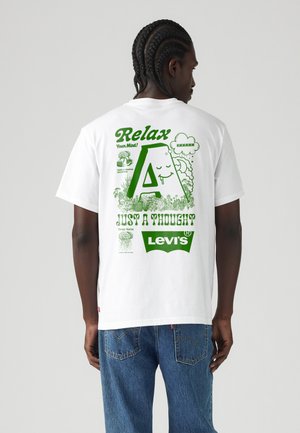 Hvid bomulds-T-shirt med grøn grafisk tekst og illustrationer på bagsiden, herunder et stort bogstav "A" og Levi's-logoet.