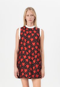 Vestido de manga corta con tejido negro con un patrón de corazones rojos y lunares, realzado por un detalle de cuello rizado blanco.