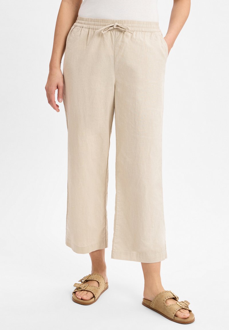 Beige linnen broek met wijde pijpen, voorzien van een elastische tailleband en een trekkoord. Opvallende details zijn de zijzakken en de zachte, gestructureerde afwerking.
