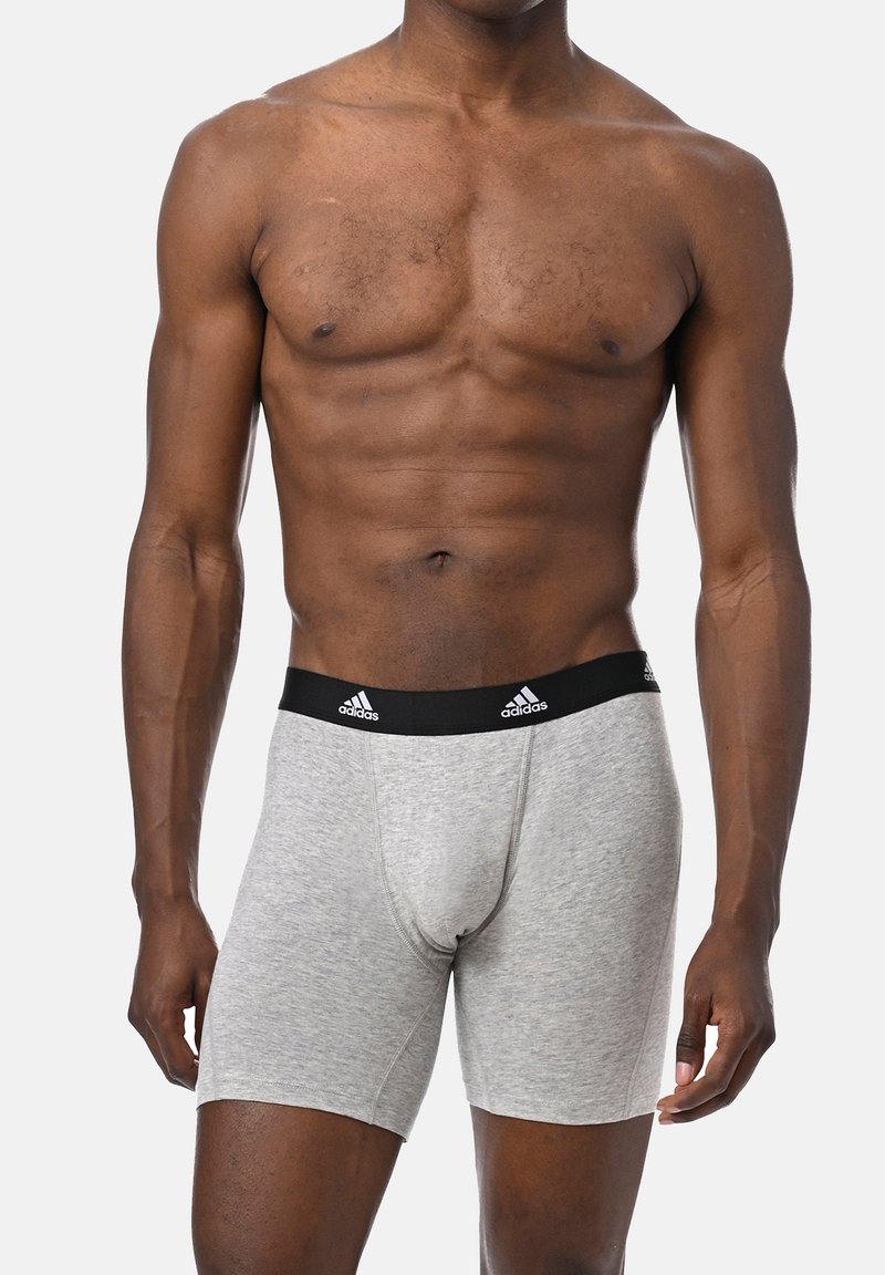 Szare bokserki z czarnym elastycznym pasem w talii z logo Adidasa. Materiał wygląda na miękki i gładki, ściśle przylegający do ciała.