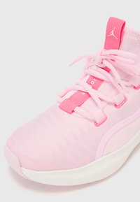 Chaussure de sport rose avec un dessus texturé, des lacets élastiques, et une languette rembourrée avec un accent de logo. Semelle rembourrée pour le confort.
