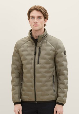 Padded olive green jacket with a high collar, horizontal quilted texture, side zip pockets, and black accents on shoulders and cuffs.