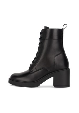 Czarny skórzany botek za kostkę z przodu sznurowany, zaokrąglonym noskiem i masywnym, szerokim obcasem. Gładka faktura i minimalne przeszycia.