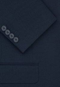 Granatowy materiał marynarki o teksturowanym wykończeniu, z mankietem na cztery guziki i kwadratową kieszenią. Guziki są czarne z gładką powierzchnią.