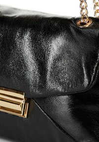 Borsa a mano in pelle nera con finitura testurizzata, dettagli in metallo dorato e tracolla a catena. Forma: rettangolare con pattina pieghevole.