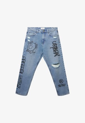 Jeans in denim di un blu chiaro con dettagli strappati e testo in stile graffiti nero, che include faccine sorridenti e frasi, sulla parte anteriore.