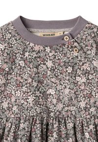 Blumenkleid aus grauem Stoff, mit rosa, weißen und grünen Blumenmustern. Gerippter lavendelfarbener Ausschnitt mit zwei Holzknöpfen und plissiertem Rock.