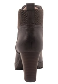 Bota marrón hasta el tobillo con un acabado de cuero suave, parte superior de punto texturado y un tacón de madera estilizado. El detalle trasero incluye una costura vertical y una pestaña de agarre.