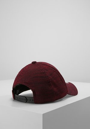 Cappellino da baseball in tessuto testurizzato color granata con cinturino regolabile a pressione nero, posizionato su una superficie bianca contro uno sfondo grigio uniforme.