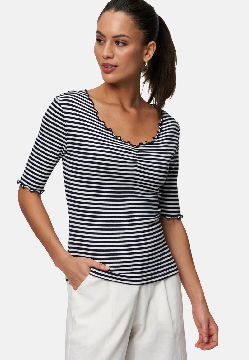 Marineblå og hvidstribet top med scalloped halsudskæring og trekvartærmer. Tyk ribbet tekstur, tætsiddende design og sidelomme.