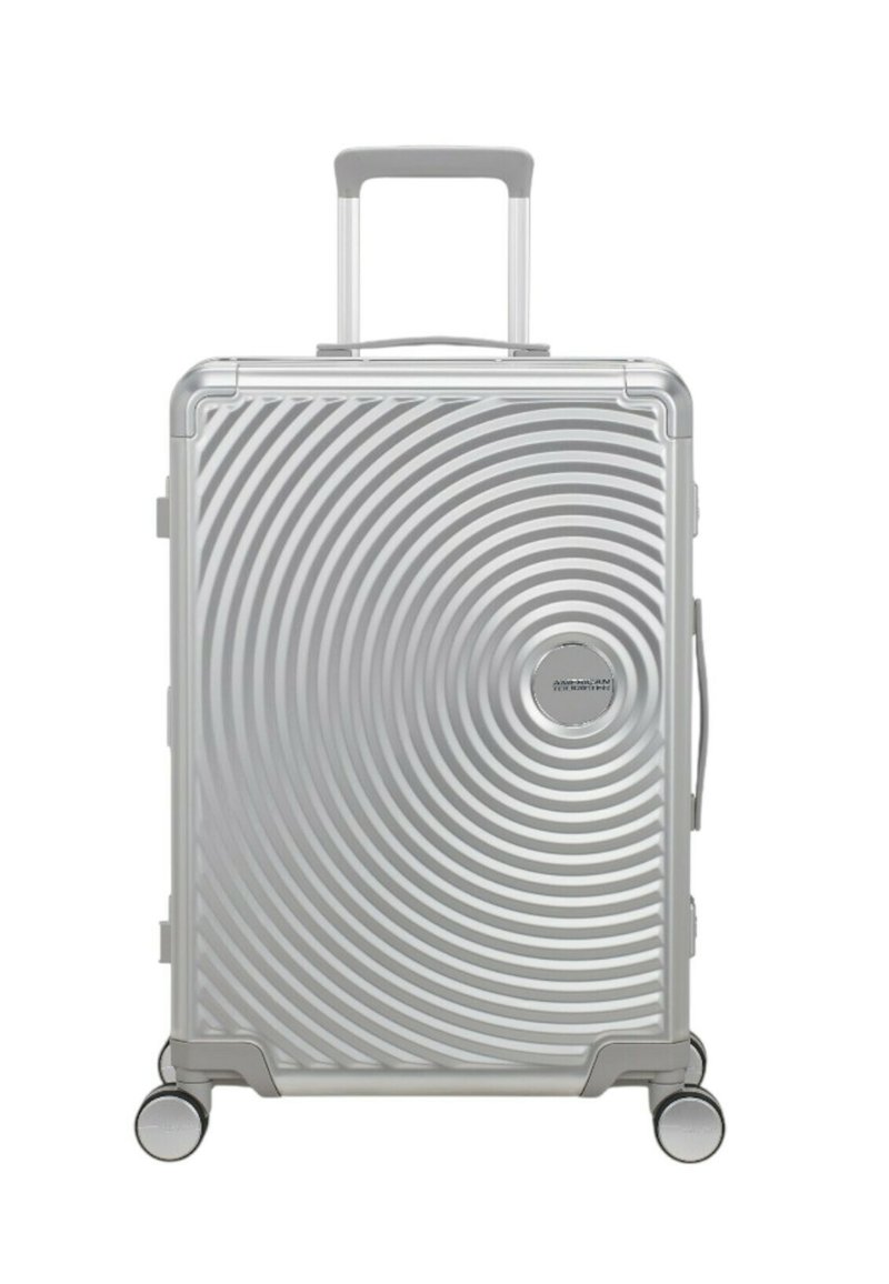 Valigia rigida argento con un motivo circolare, manico estensibile e quattro ruote per la mobilità. Presenta una maniglia laterale per il trasporto.