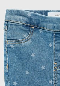 Světle modré džíny z denimu se vzorem hvězd, viditelnými švy a přední kapsou, představující hladkou strukturu a ležérní design.