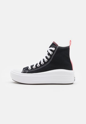 Baskets montantes en toile noire avec lacets blancs, semelle plateforme blanche épaisse et languette rose au talon, vues de profil.