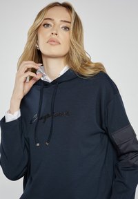 Granatowy hoodie z sznurkiem, z haftowanym logo z przodu i kontrastowym wykończeniem na rękawach.