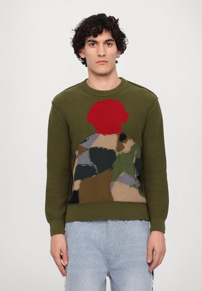 Green knitted sweater featuring a colorful patchwork design with a red accent at the top, round neckline, and ribbed cuffs and hem.