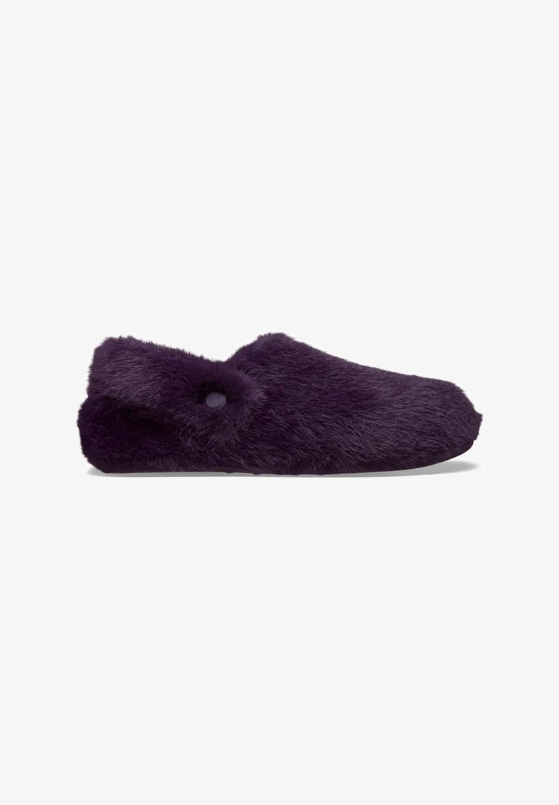 Zapatilla de felpa morada con punta redondeada, exterior de textura difusa y un detalle de botón decorativo en el costado. Diseño suave y acogedor.