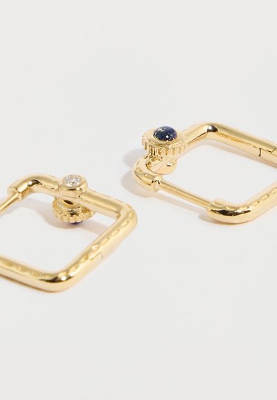 Orecchini a cerchio quadrati in oro con un design testurizzato, uno impreziosito da una pietra trasparente e l'altro da una pietra blu.