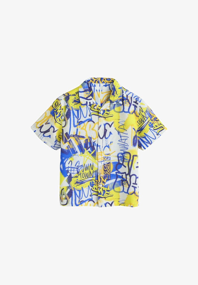 Chemise à manches courtes boutonnée avec un imprimé abstrait de style graffiti en jaune, bleu et blanc, comprenant du texte et des formes artistiques.