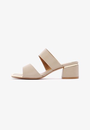 Mule beige con tacco aperto sulla punta, due larghe fasce e tacco a blocco con un dettaglio dorato sottile.