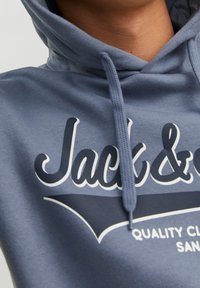 Szary hoodie z troczkiem, z białym i granatowym napisem "Jack &" oraz "QUALITY CLOTHES" z przodu. Miękka tkanina i klasyczny design.