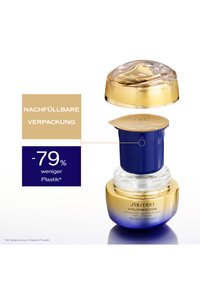 Shiseido Vital Perfection Creme in einem nachfüllbaren Behälter. Verfügt über einen transparenten Kuppeldeckel, goldene Akzente und einen blau-weißen Sockel. Text sichtbar.