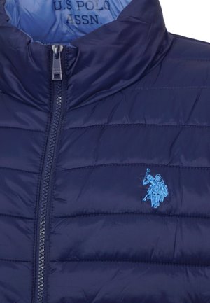 Marineblaue gesteppte Jacke mit durchgehendem Reißverschluss vorne und hellblauem, besticktem U.S. Polo Assn. Logo mit zwei Polospielern auf Pferden.