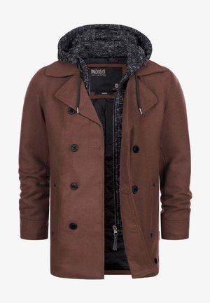 Smeđi dvostruko zatvoreni kaput s crnim dugmadi složen preko crne i sive zip-jakne s kapuljačom i špagama.