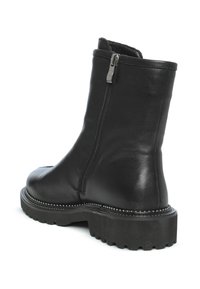 Zwarte leren enkellaars met een zijrits, textuurafwerking, grove rubberen zool en zilverkleurige studs langs de rand.