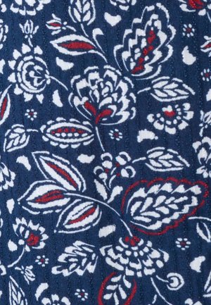 Tessuto blu navy con motivo floreale bianco e rosso che presenta foglie stilizzate, fiori e gambi curvi in un disegno ripetuto.