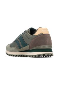 Zapatilla deportiva verde y gris con materiales de ante y sintéticos, que presenta tres franjas verdes, un acento en el talón beige y una suela texturizada.