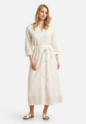 Langes, weißes, knopfbares Kleid aus leichtem Stoff mit 3/4-Ärmeln, einem Bindegürtel in der Taille und Durchbrüche aus Blumenmuster. 