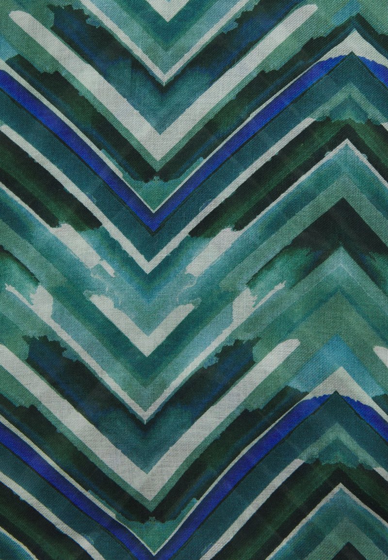 Tissu présentant un motif en zigzag dans des nuances variées de vert, de bleu et de crème, avec une texture aquarelle et une finition lisse et tissée.