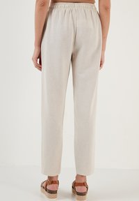 Lichtbeige linnen broek met een ontspannen pasvorm, met een elastische taille en rechte pijpen, zonder opvallende patronen of accenten.