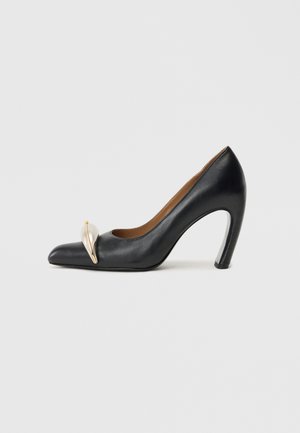 Black leather high heel pump with a pointed toe, featuring a gold decorative accent on the toe cap and a sleek stiletto heel.