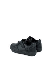 Zapatillas de cuero negro con perfil bajo, caja de dedos perforada, cierre de cordones en la parte delantera y correa de Velcro. Presenta una suela de goma texturizada.