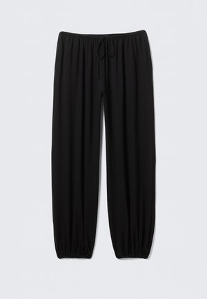 Pantalon noir à coupe ample en tissu doux ; doté d'une ceinture élastique avec cordon de serrage ajustable, chevilles fuselées, sans motifs.