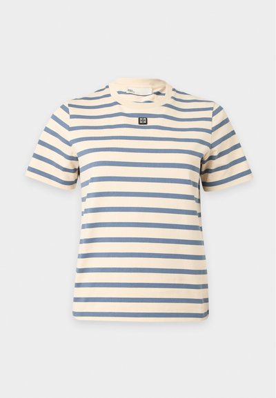 Κοντομάνικο κρεμ T-shirt με οριζόντιες μπλε ρίγες και ένα μικρό ασπρόμαυρο τετράγωνο λογότυπο στο κέντρο του στήθους.