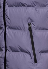 Doudoune violette avec une finition texturée, dotée d'une poche zippée et d'un détail de zip noir sur le panneau avant.