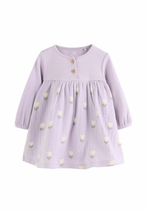 Fialové šaty s rebrovaným vrškom, dlhými rukávmi, drevenými gombíkmi a rozšíreným spodkom s kvetinovým vzorom v krémovej a zelenej farbe.