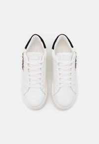 Vita lädersneakers med rund tå, svarta mockadetaljer vid hälen och vita snören. Utsmyckade med dekorativa element på sidan.