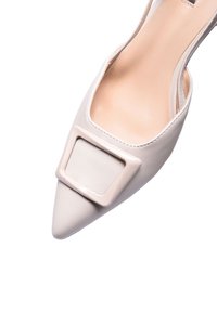 Décolleté a punta in morbida pelle beige con una fibbia quadrata lucida sulla tomaia, caratterizzato da una texture liscia e un design con schiena aperta.