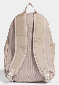 Light beige backpack with padded, breathable mesh straps and sides, featuring a simple design, adjustable hardware, and smooth fabric texture.