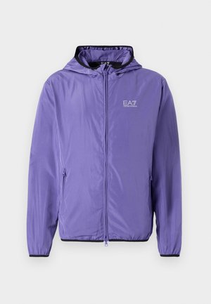 Lett lila jakke laget av glatt stoff, med hette, frontglidelås og svarte detaljer ved mansjettene og nederkanten. EA7-logo på brystet.