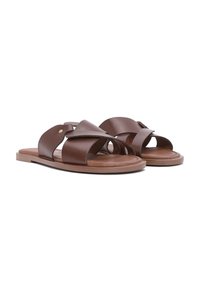 Paire de sandales marron en cuir à enfiler avec de larges brides qui se chevauchent et des semelles plates sur fond blanc.