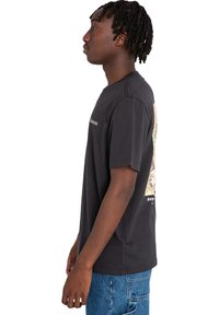 Black cotton t-shirt with short sleeves, featuring a colorful graphic and text on the back. Straight cut and ribbed neckline.