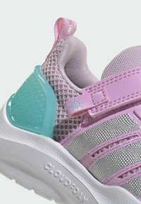 Chaussure de sport rose et grise avec tige en mesh, accents réfléchissants et support de talon en plastique teal. Caractéristiques : sangle Velcro et semelle texturée.