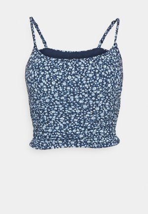 Námornícky kvetinový crop top s malými modro-bielymi kvetmi, tenkými nastaviteľnými ramienkami a zhrnutou textúrou na zakončení. Hladká látka.