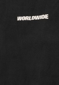 Black fleece fabric featuring the text "WORLDWIDE" in bold white letters, with a soft texture and plain design. No additional patterns.